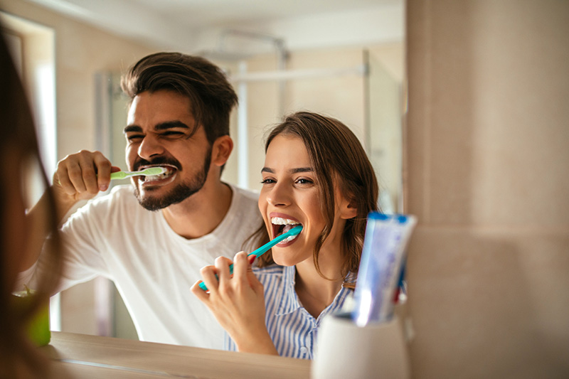Молодая пара вместе чистит зубы